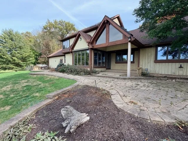 Back of house with a patio area and a yard