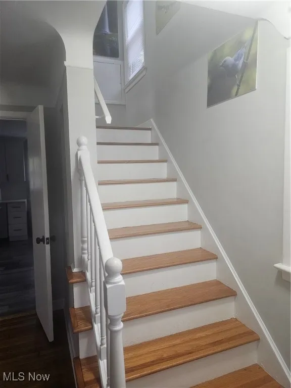 Stairs with wood finished floors and baseboards
