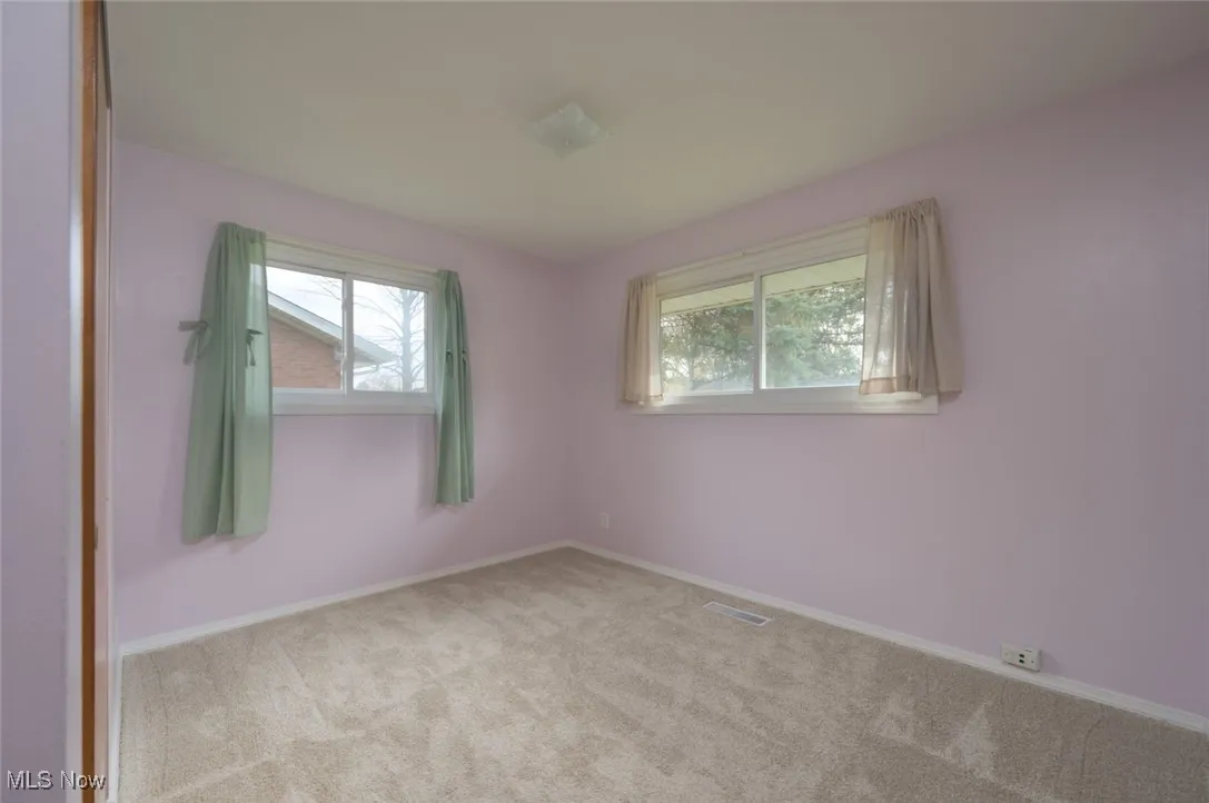 Bedroom featuring carpet, windows and a closet.