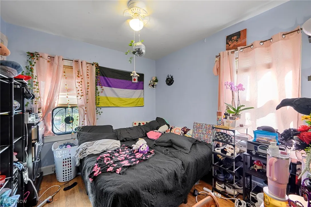 Bedroom featuring wood finished floors and multiple windows