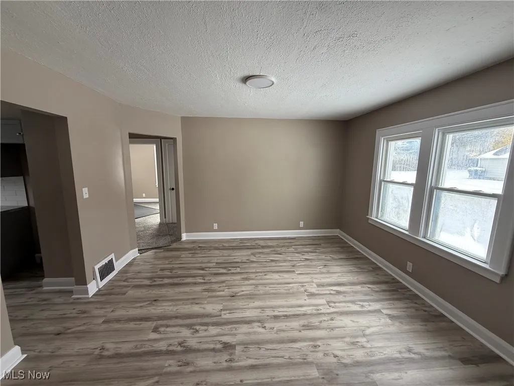 Spare room featuring a textured ceiling and light wood-style floors