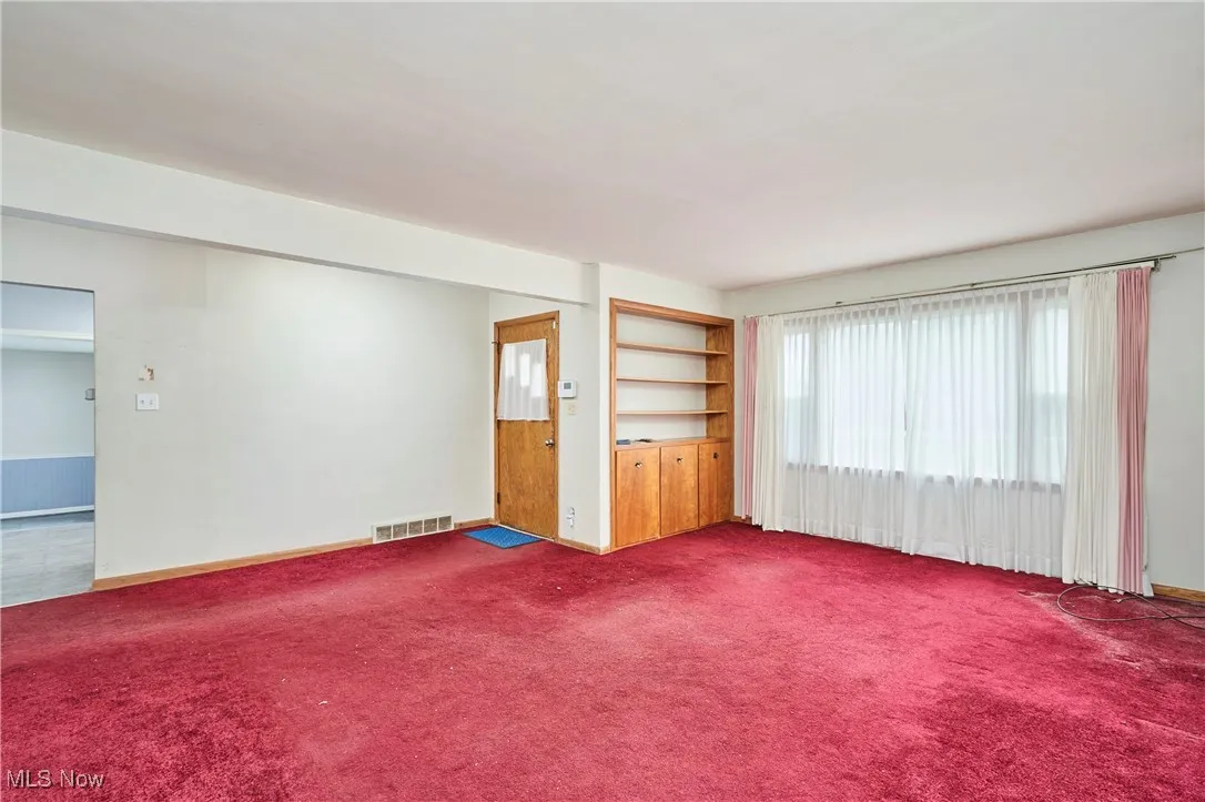 Unfurnished room with baseboards and carpet