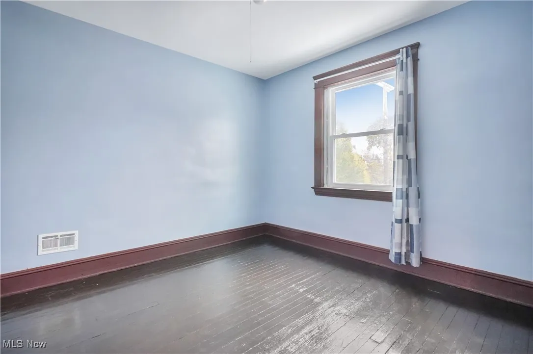 Bedroom featuring dark wood-style floors and baseboards