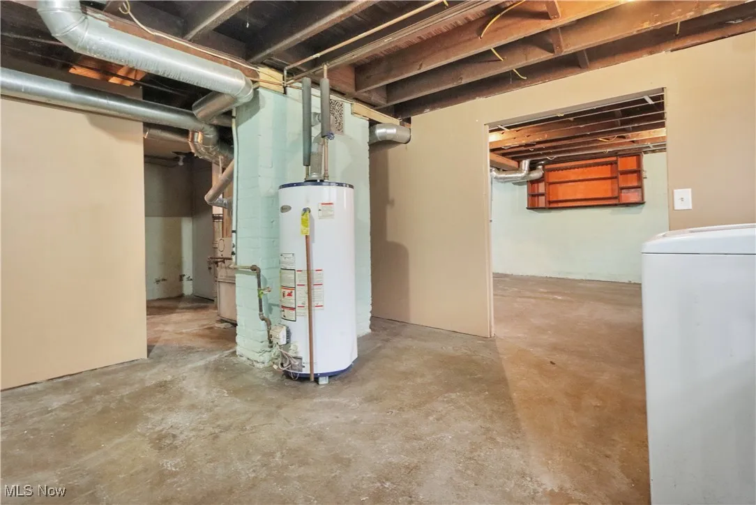 Unfinished basement featuring washer / clothes dryer and gas water heater
