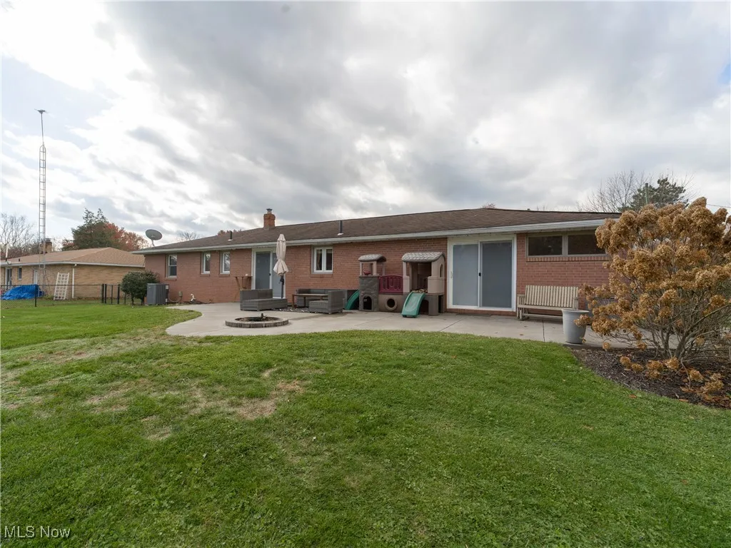 Back of property featuring a patio area, brick siding, and a chimney