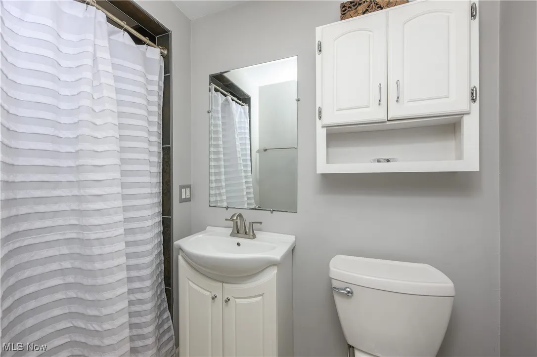 Full bath with a shower with shower curtain and vanity