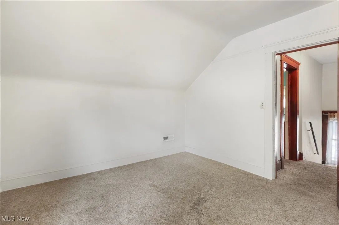 Bonus room with lofted ceiling and carpet flooring