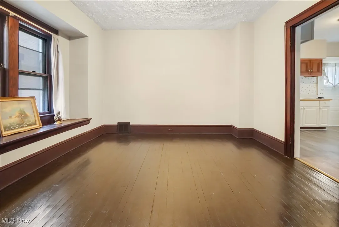 Dining room featuring dark wood-style flooring and a textured ceiling
