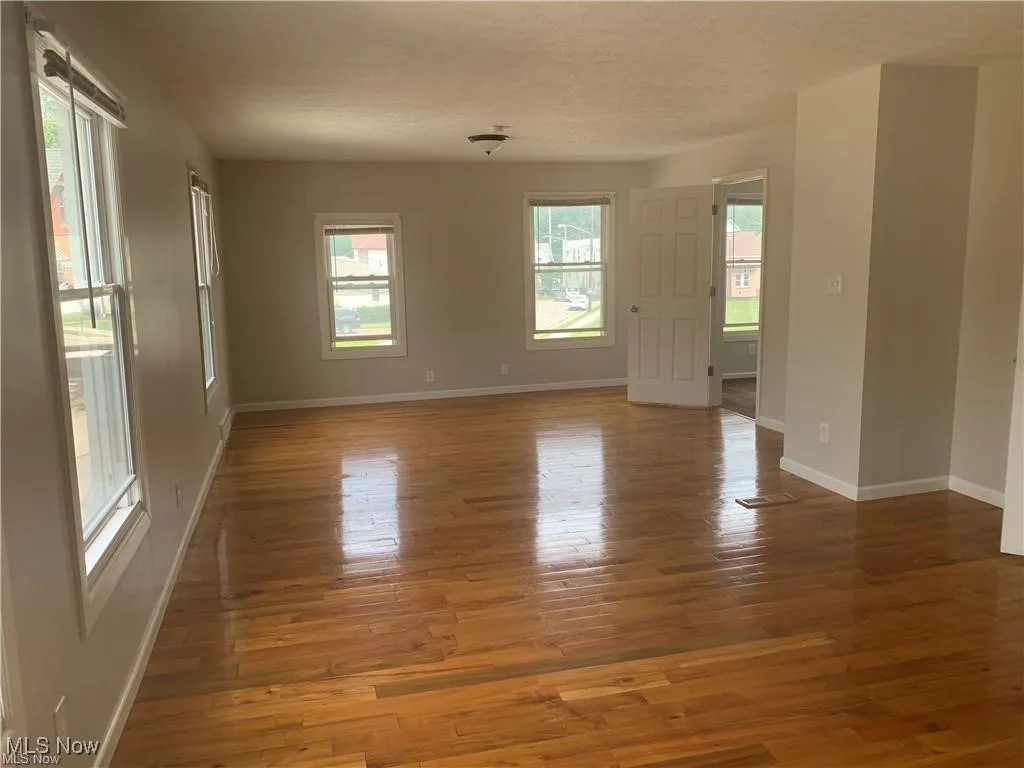 Empty room featuring light wood-style flooring and a textured ceiling