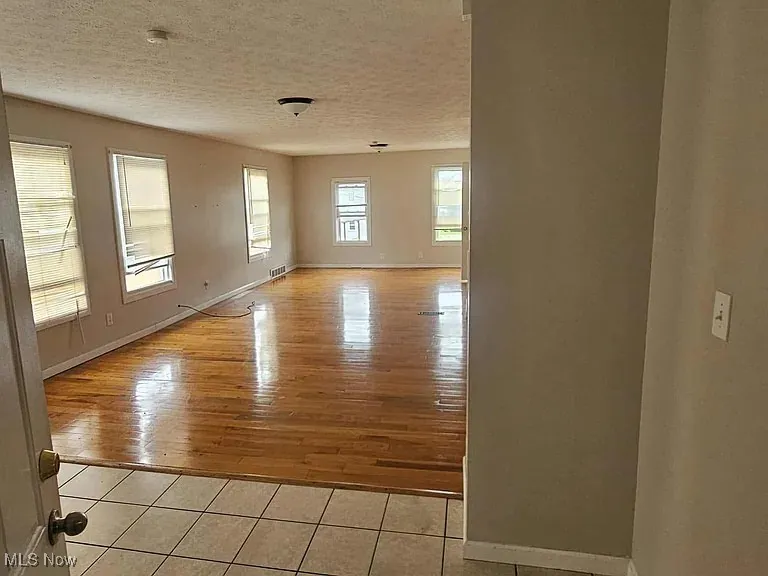 Unfurnished room featuring a textured ceiling and light tile patterned flooring