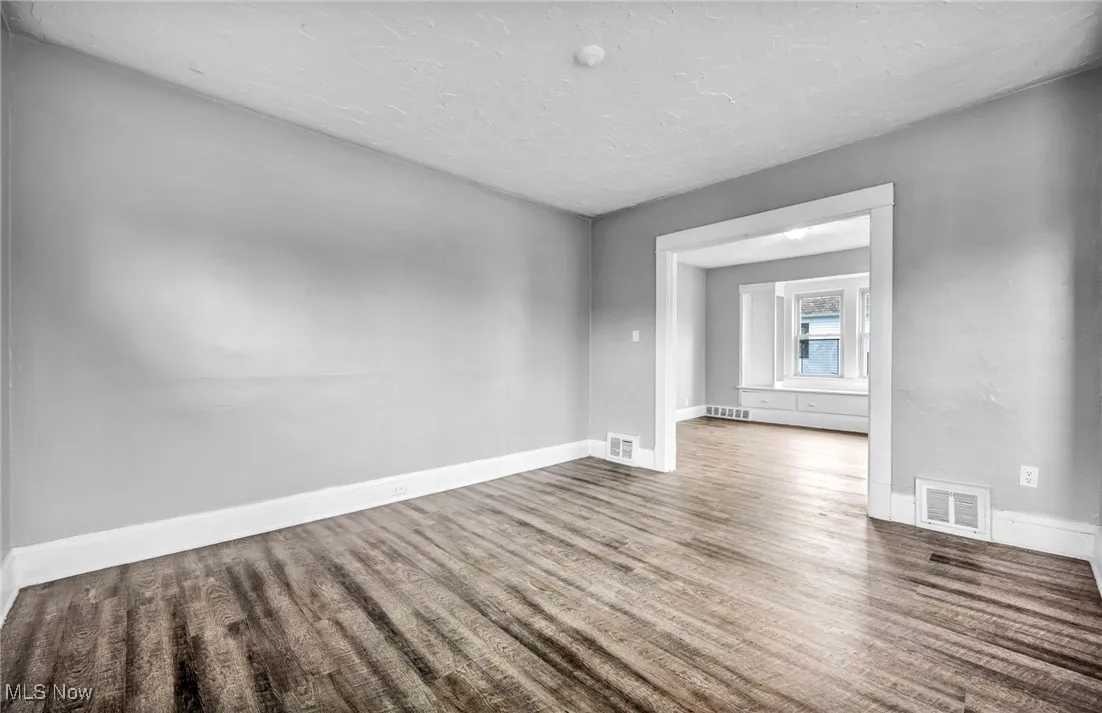 Spare room featuring wood finished floors and a textured ceiling