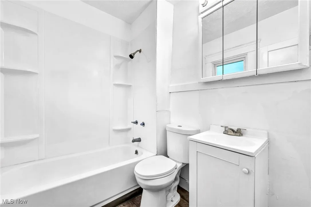 Bathroom with vanity, tub / shower combination, and a textured ceiling