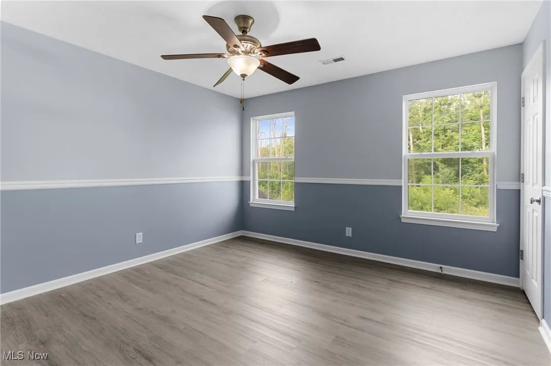 Empty room featuring wood finished floors and ceiling fan