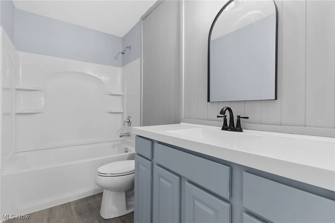 Bathroom with light wood-style floors, shower / bathtub combination, and vanity