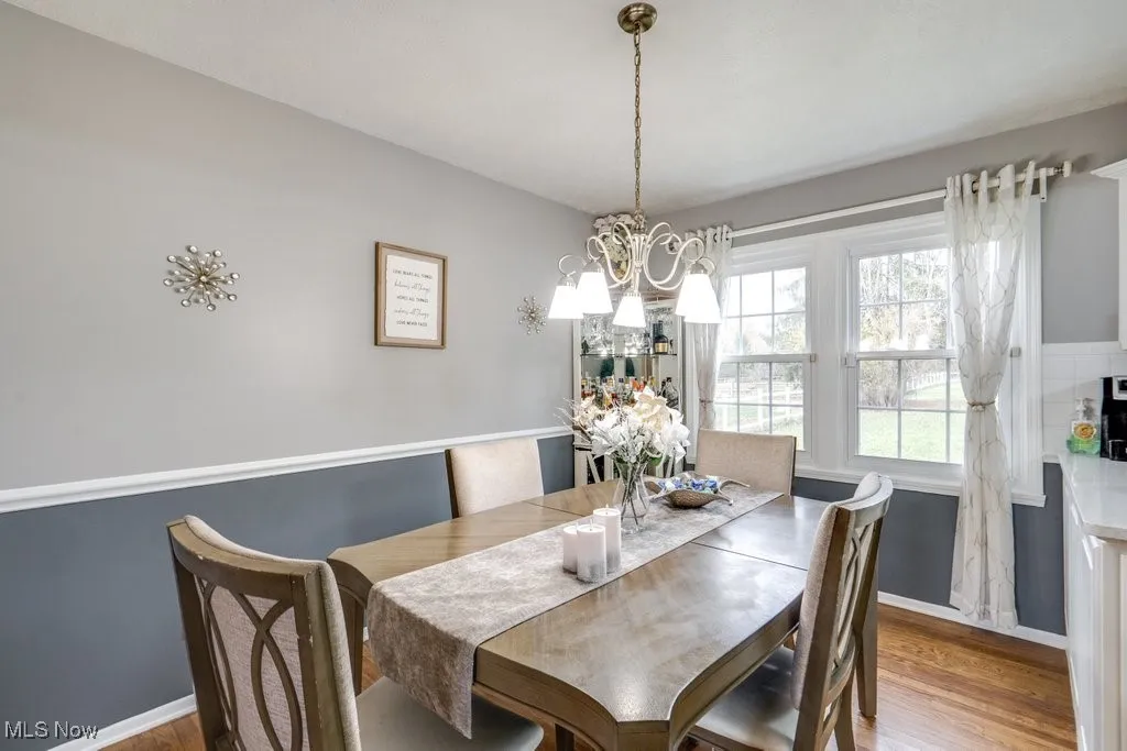 Dining area featuring wood finished floors and a chandelier