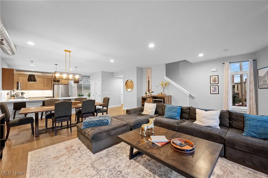 Living area with light wood-type flooring and recessed lighting