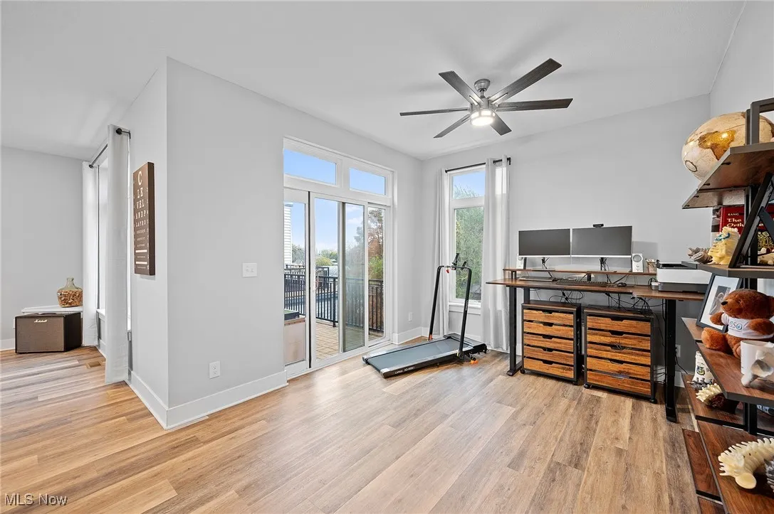 Office area with light wood finished floors and ceiling fan