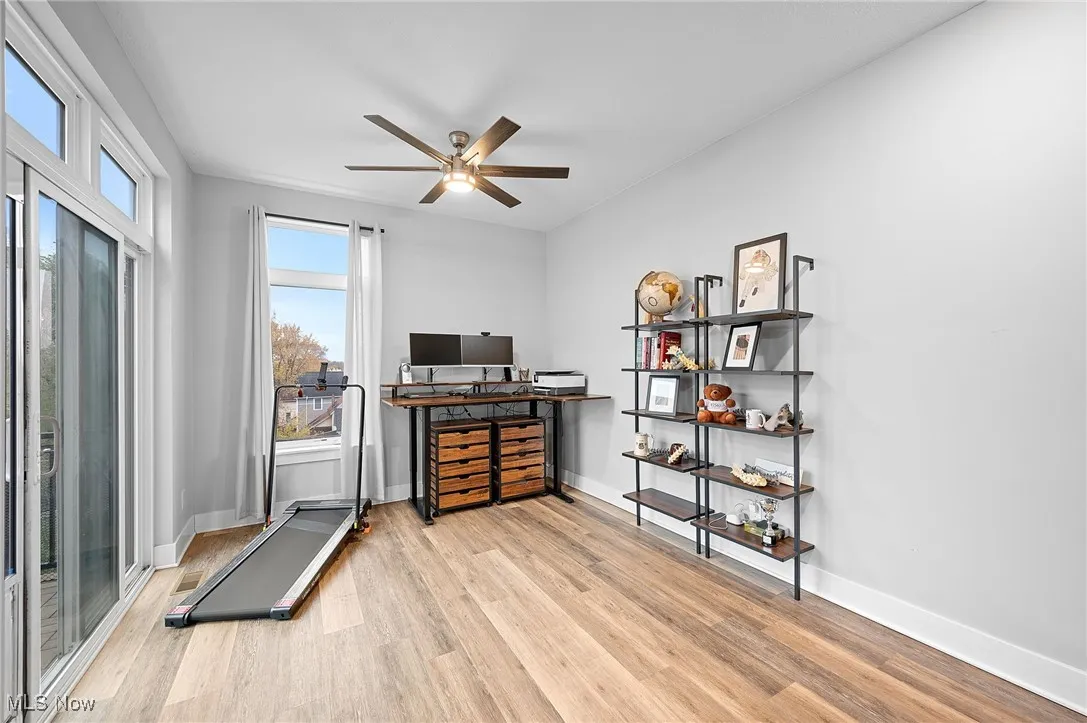 Workout area featuring light wood-style floors and a ceiling fan