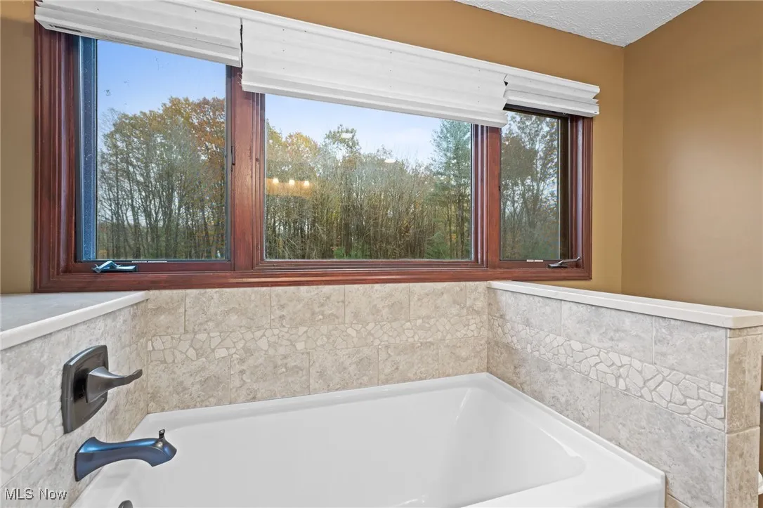 Bathroom featuring a bath and a textured ceiling