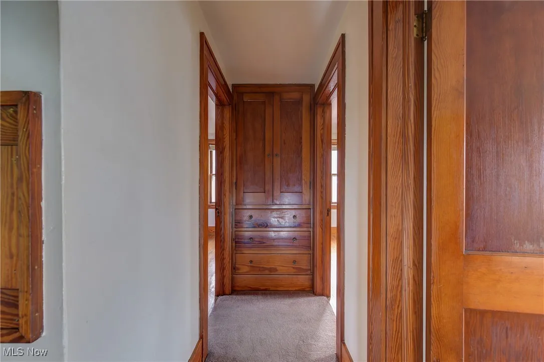 Corridor featuring wooden built in storage