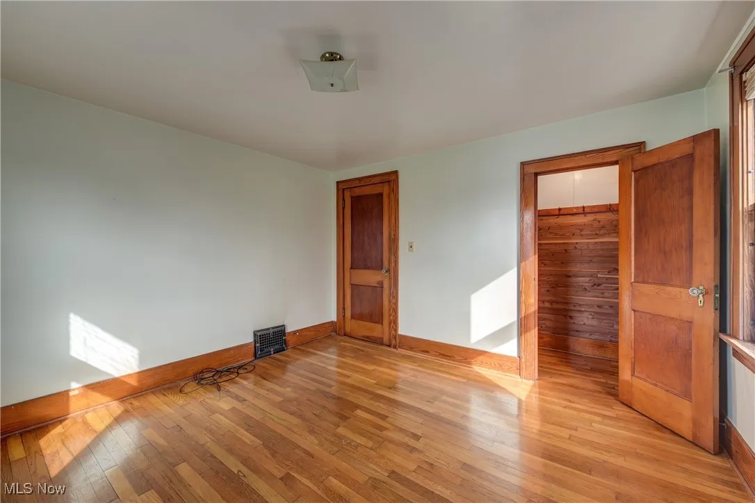 Bedroom featuring light wood flooring, baseboards and a cedar closet