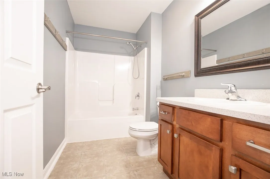Full bathroom featuring vanity, shower / bath combination, and light tile patterned floors