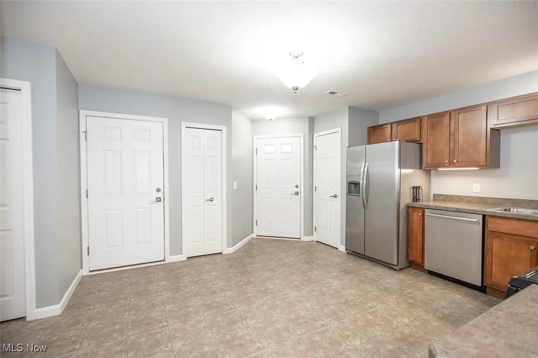 Kitchen featuring brown cabinetry, stainless steel appliances, and light countertops