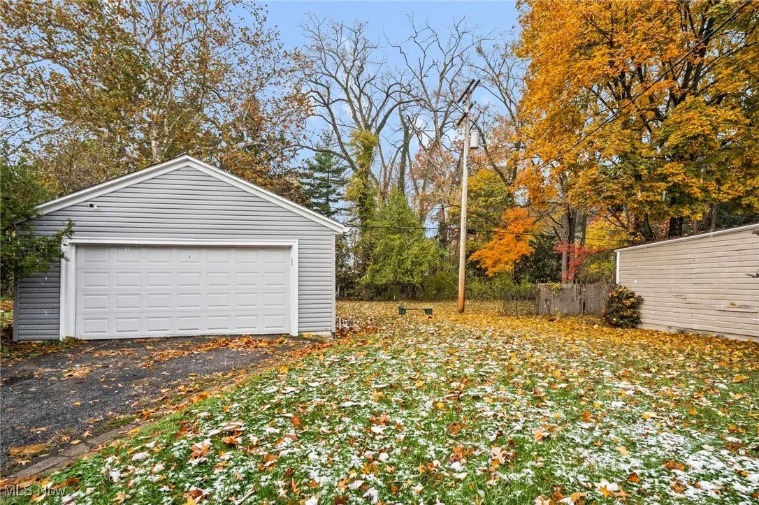 Detached garage featuring view of wooded area