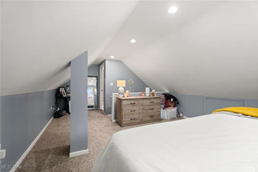 Bedroom featuring light colored carpet, vaulted ceiling, and recessed lighting