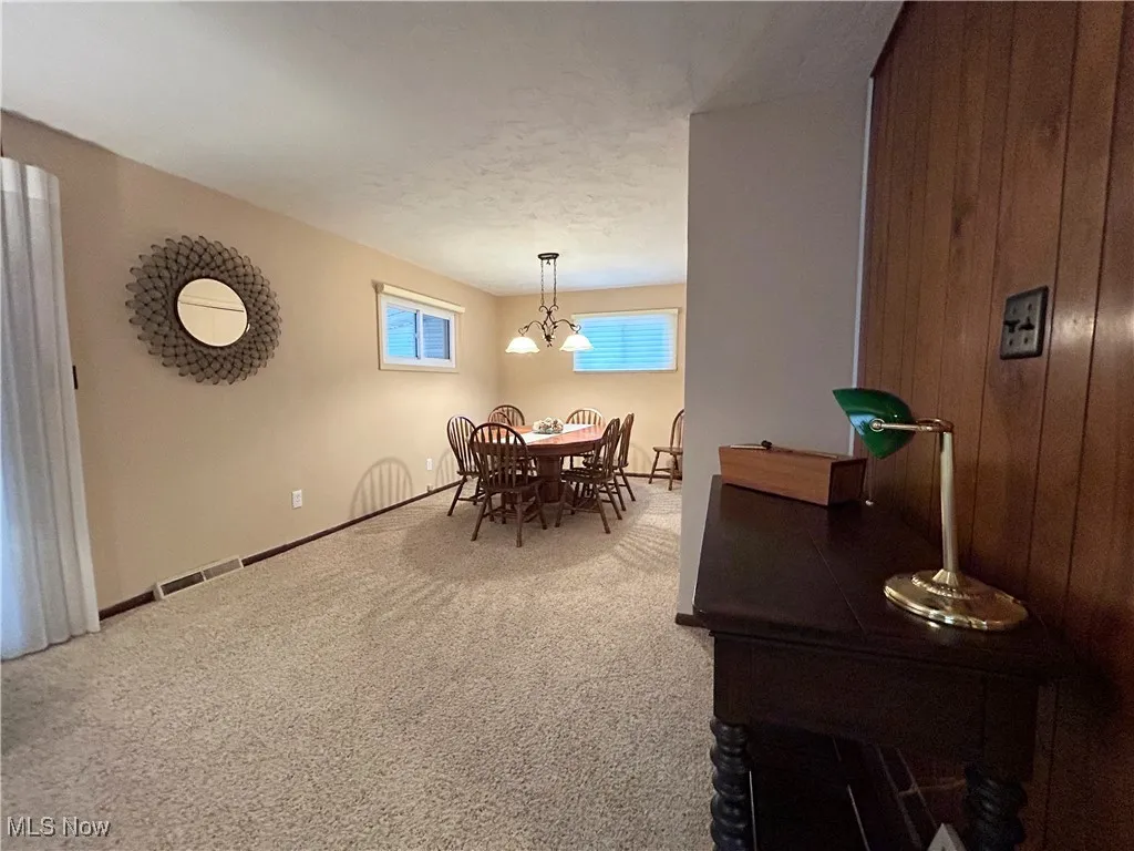 Carpeted dining room with a textured ceiling and baseboards