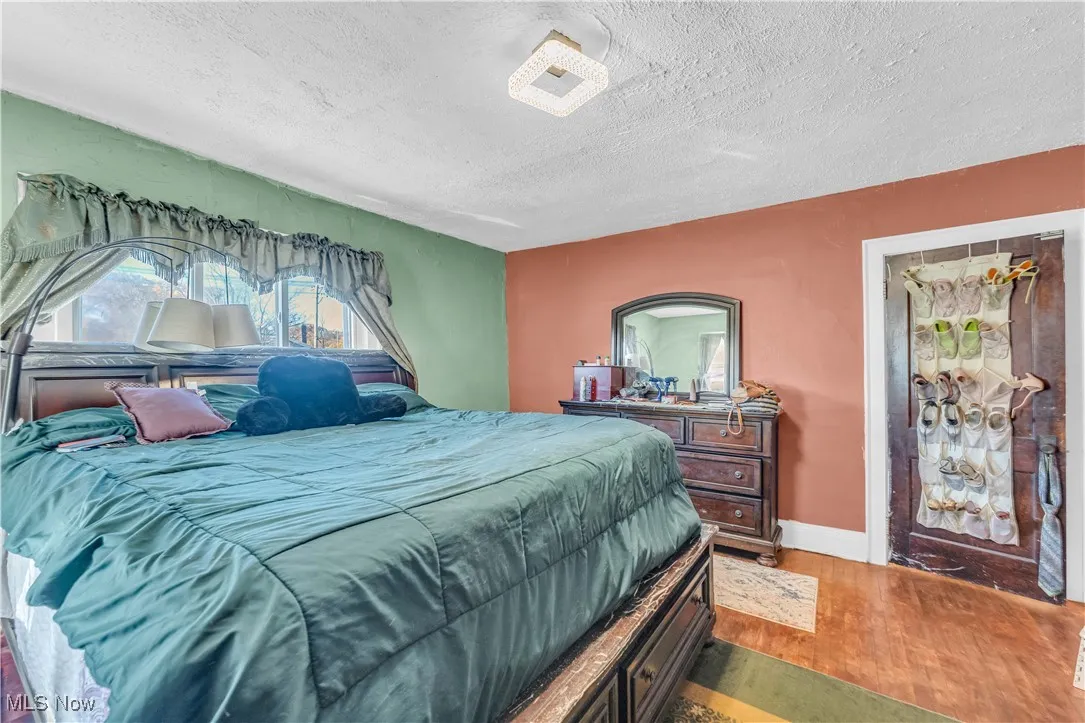 Bedroom with wood finished floors and a textured ceiling