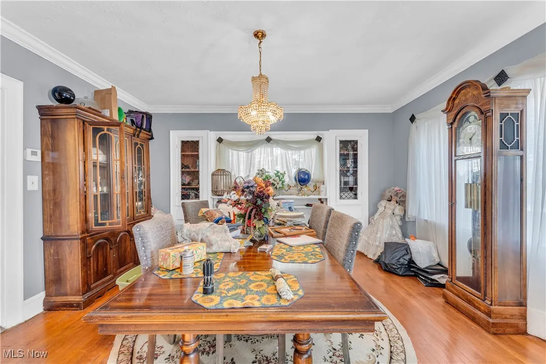 Dining area featuring light wood finished floors, a chandelier, and ornamental molding