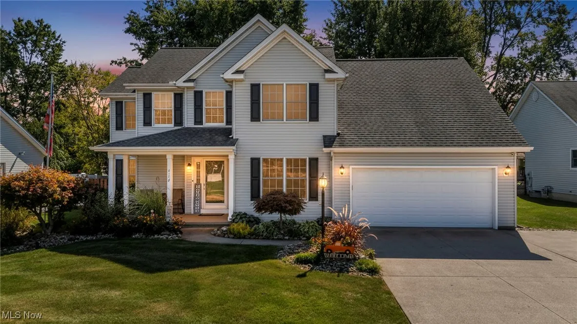 Home featuring covered porch, a front yard, driveway.