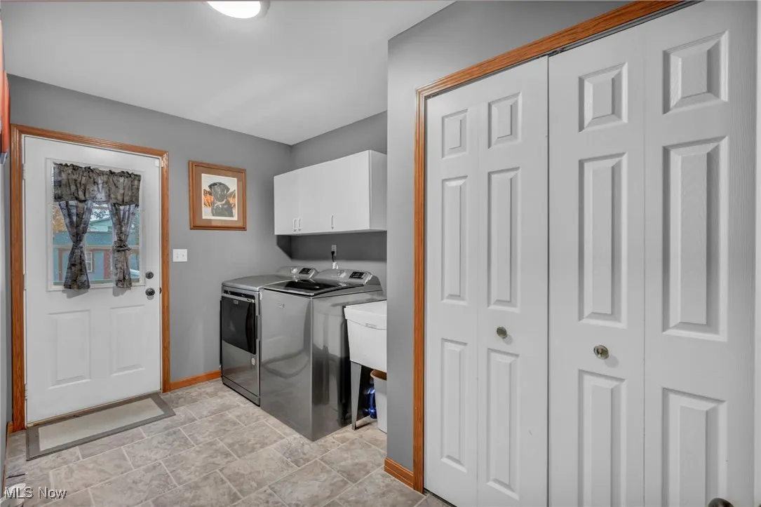 Washroom with cabinet space, washer and clothes dryer
