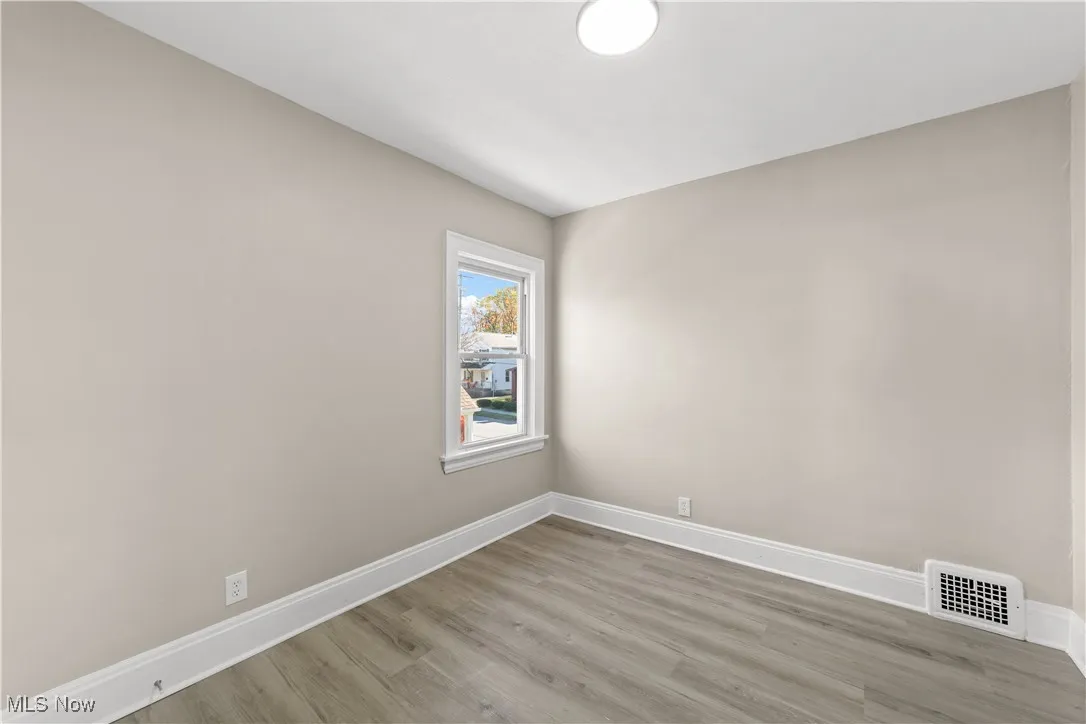 Unfurnished room featuring baseboards and light wood finished floors