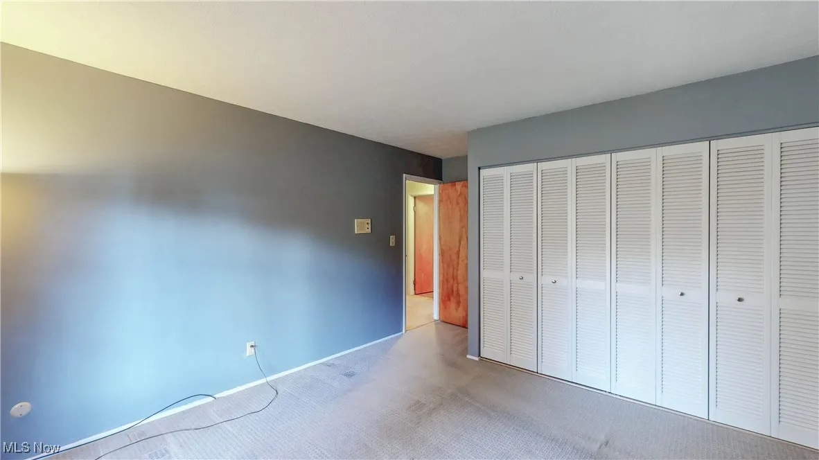 Unfurnished bedroom with carpet flooring and a closet