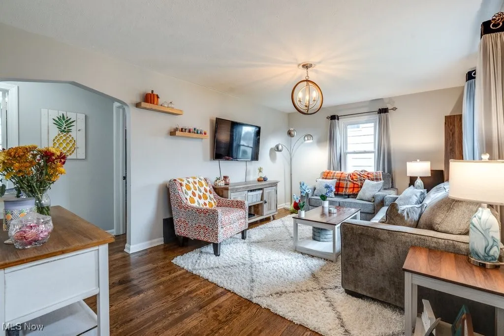 Living area with dark wood-type flooring and a chandelier