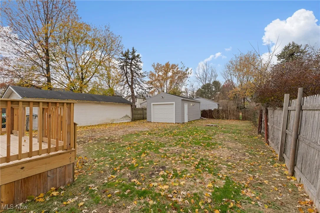 Fenced backyard with an outbuilding and a deck