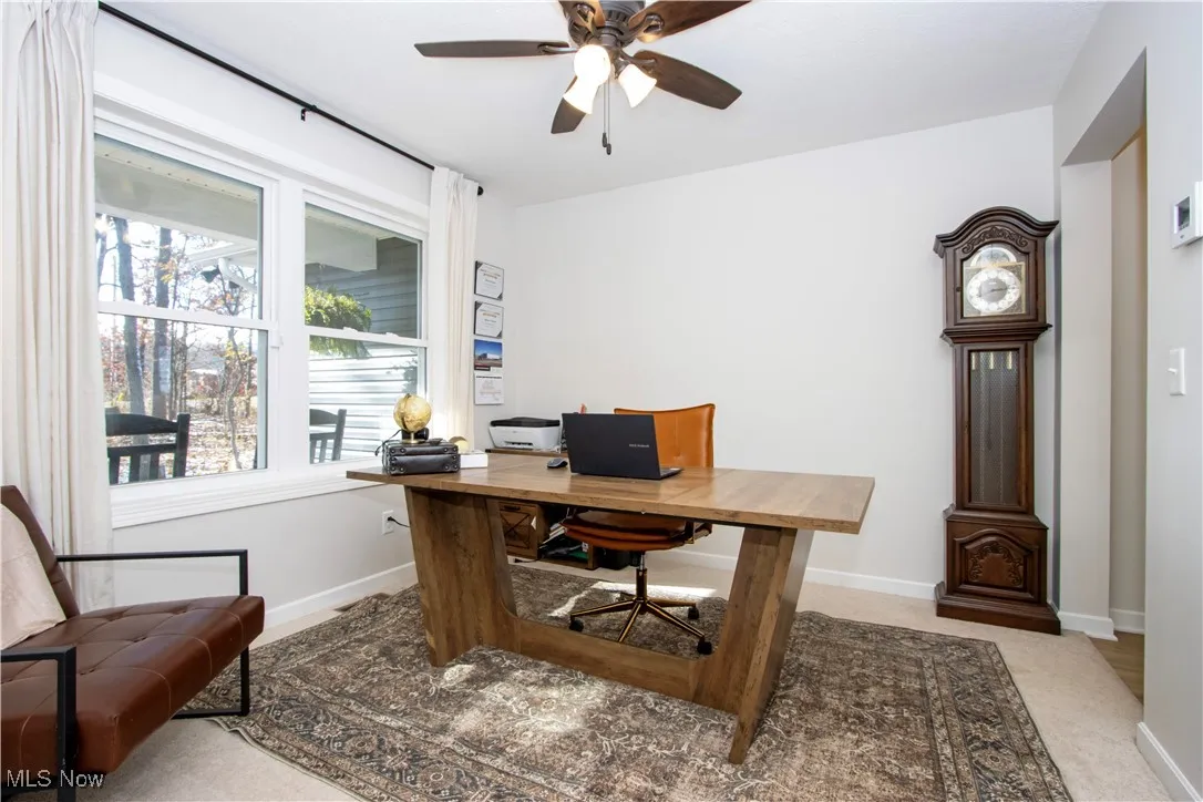 Home office with ceiling fan and light carpet