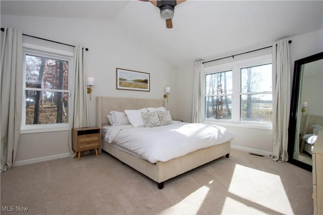 Bedroom featuring carpet floors, vaulted ceiling, and ceiling fan