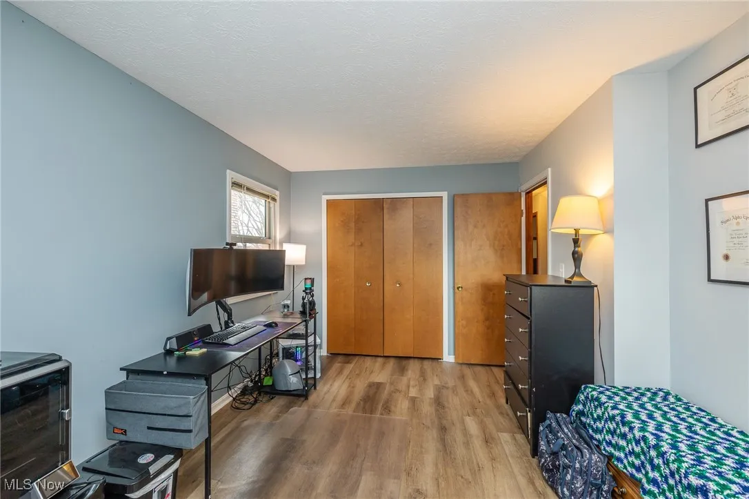 Office featuring light wood-style flooring and a textured ceiling