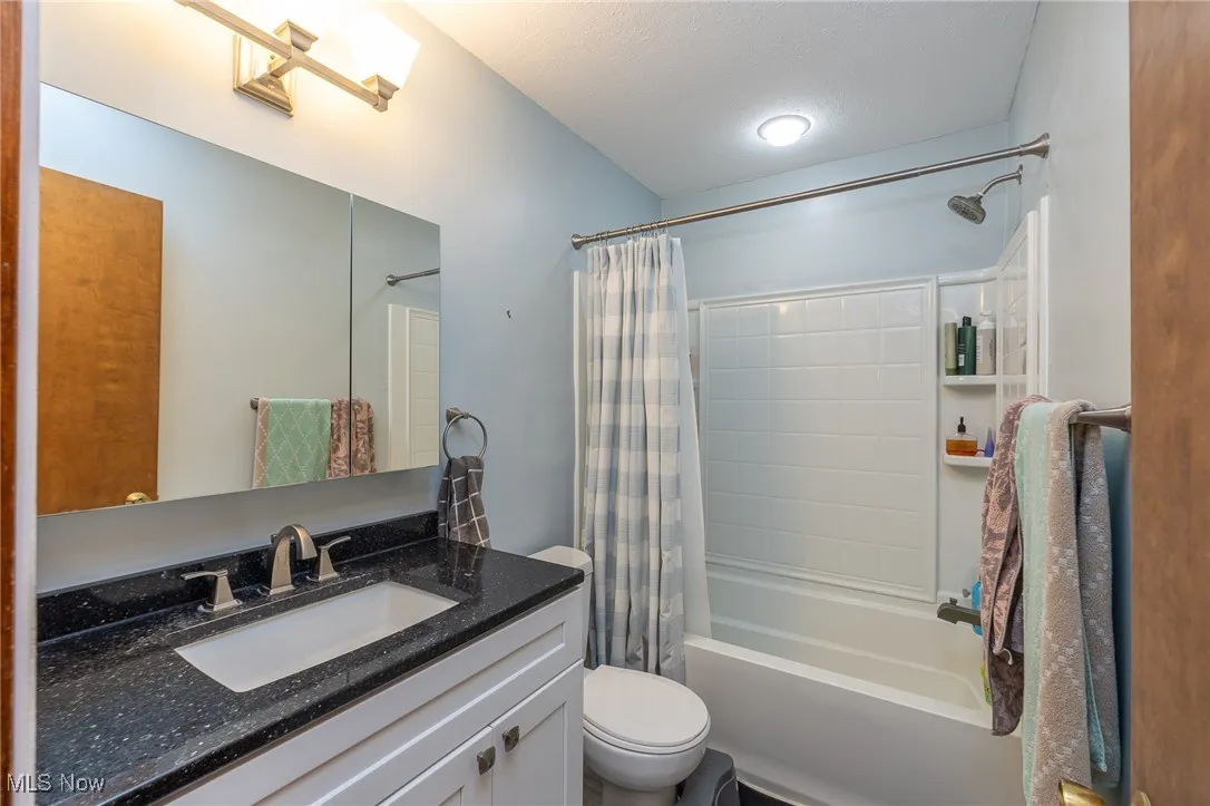Full bathroom with vanity and shower / bathtub combination with curtain