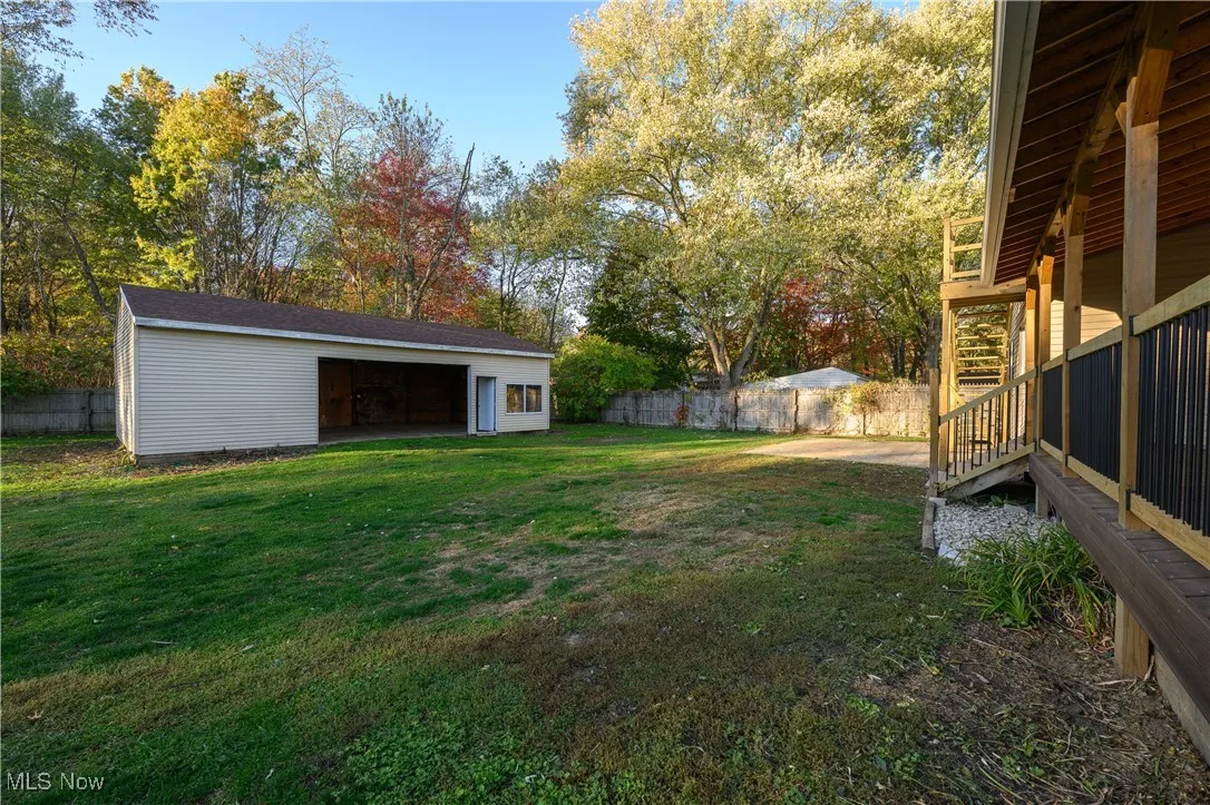 Fenced backyard with an outdoor structure and a garage
