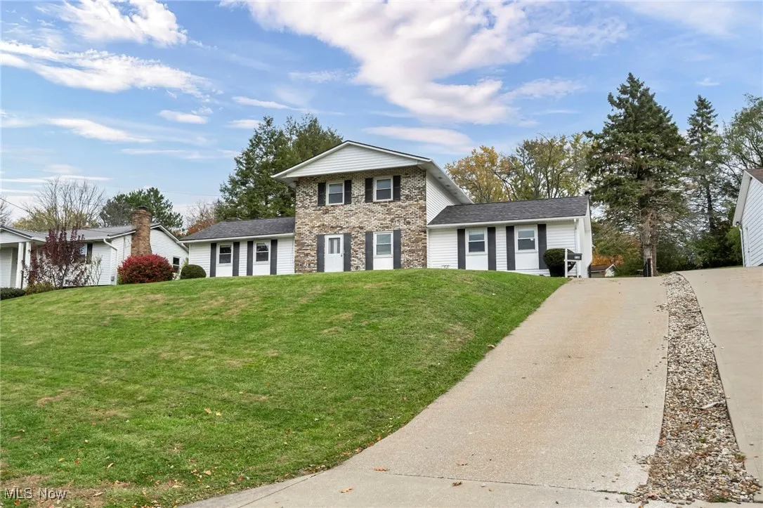 Traditional home featuring brick and vinyl siding and a front yard