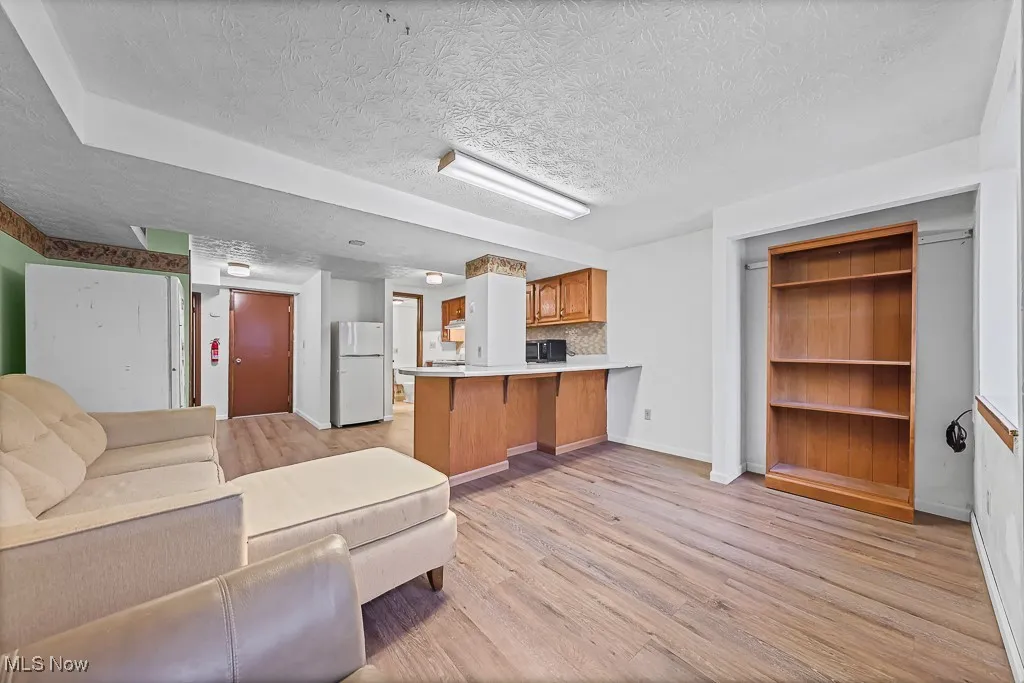 Living room featuring light wood-style floors and a textured ceiling