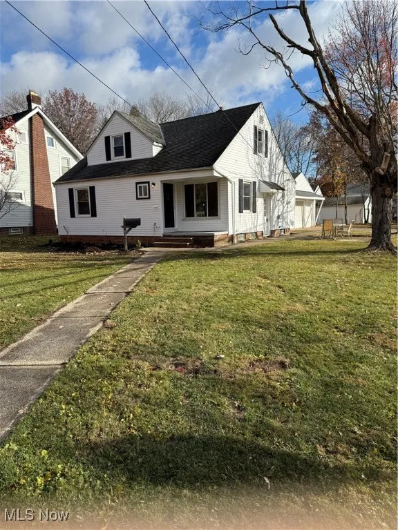 View of front of home with a front lawn, covered porch, and roof with shingles