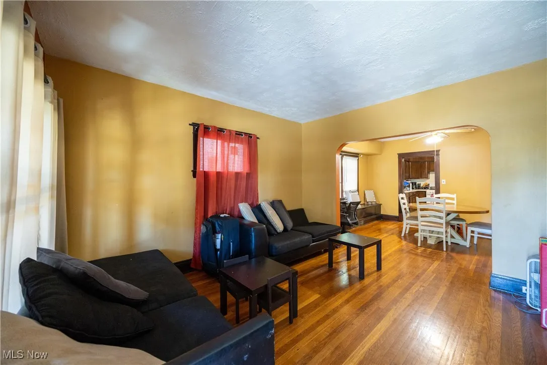 Lower unit family room featuring arched walkways, and hardwood / wood-style floors