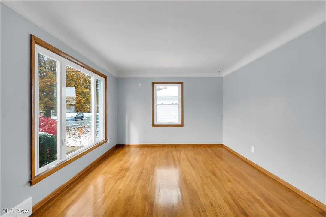 Spare room with light wood finished floors and ornamental molding