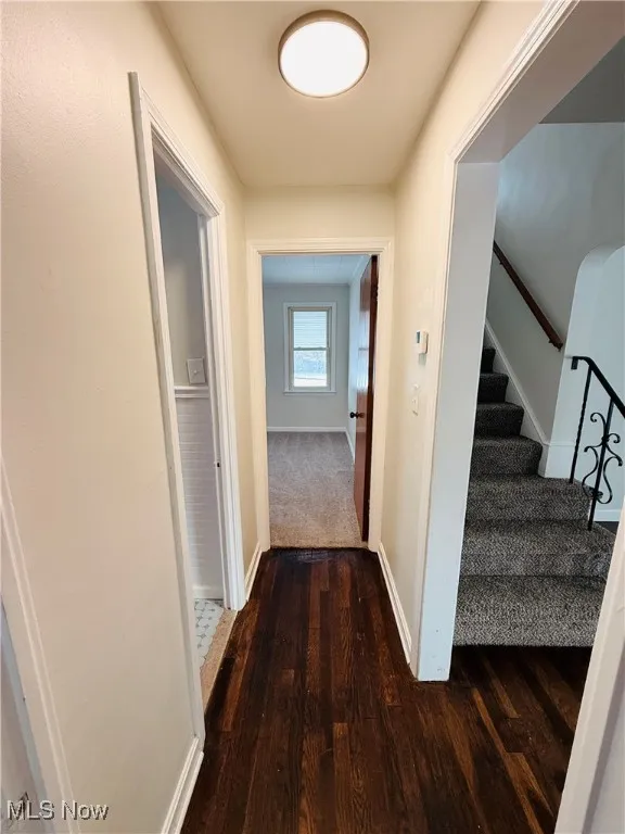 Hall featuring stairway and dark wood-style floors