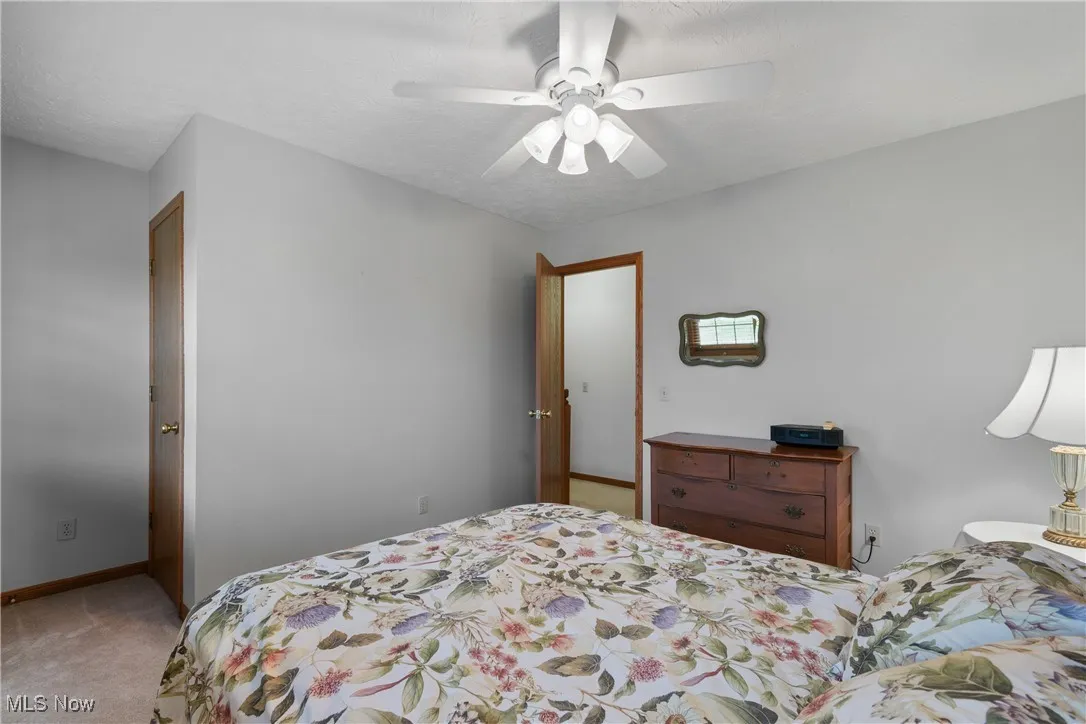 Bedroom featuring carpet floors, ceiling fan, and a textured ceiling